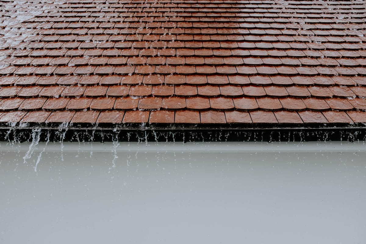 Water overflowing from a roof without proper downspout drainage